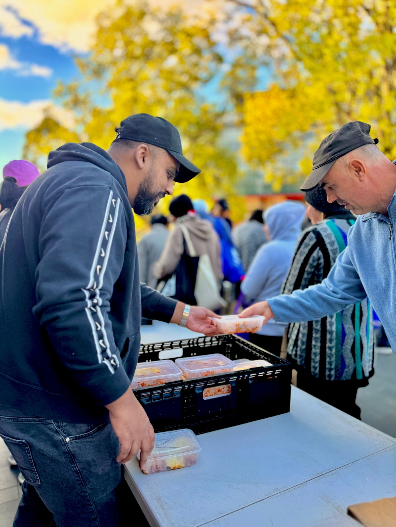 Sumeet Joseph handing over a meal while working with Our Community Kitchen in Liverpool